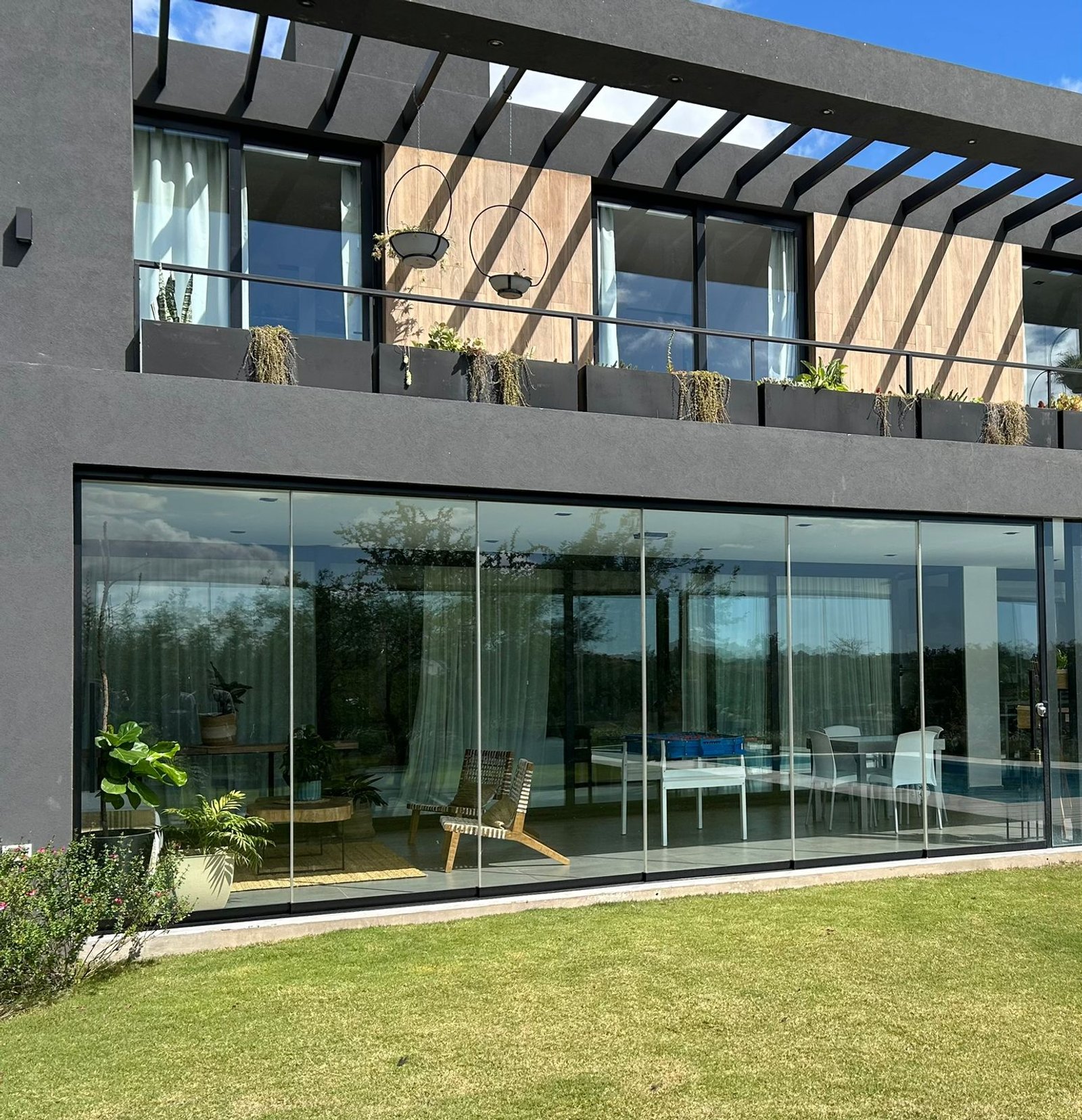 fachada moderna com vidro do chão ao teto e pergolado — projeto EL TERRON, por GARCIA RECTA DESIGN, em Ruta intermunicipal